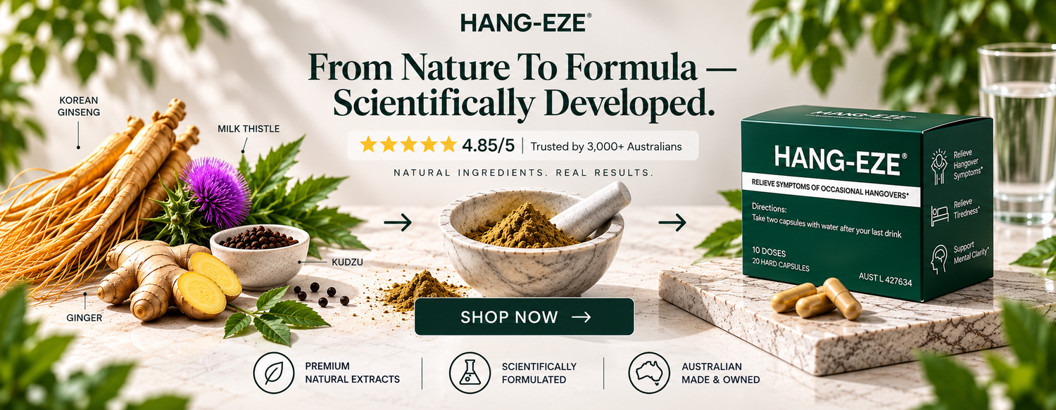 Hang-EZE herbal supplement box shown beside ingredients and bowls on a styled tabletop with a white background. The box is dark green with white text, and the scene includes ginger, milk thistle, Korean ginseng, a purple flower, a mortar and pestle, and a glass of water.